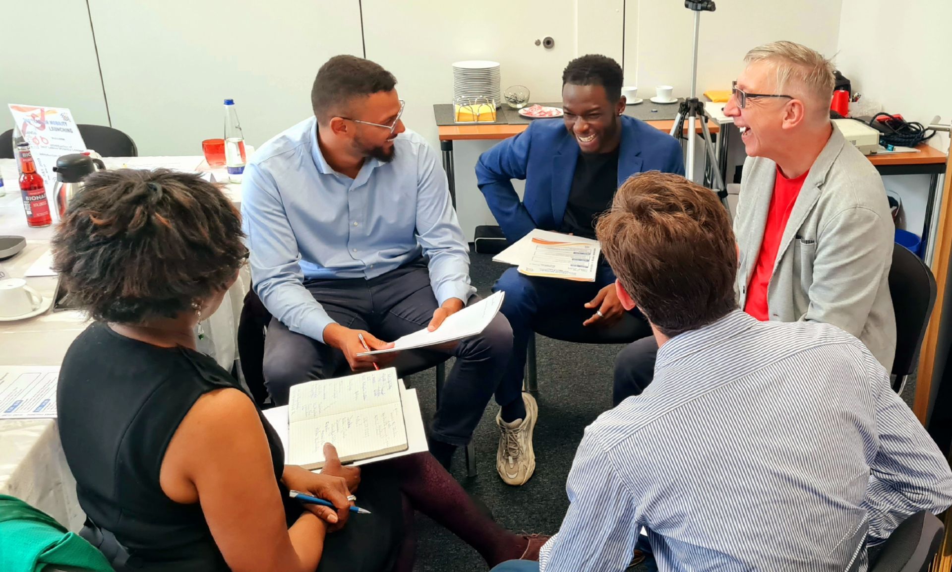 A group of people are sitting in a circle talking to each other.