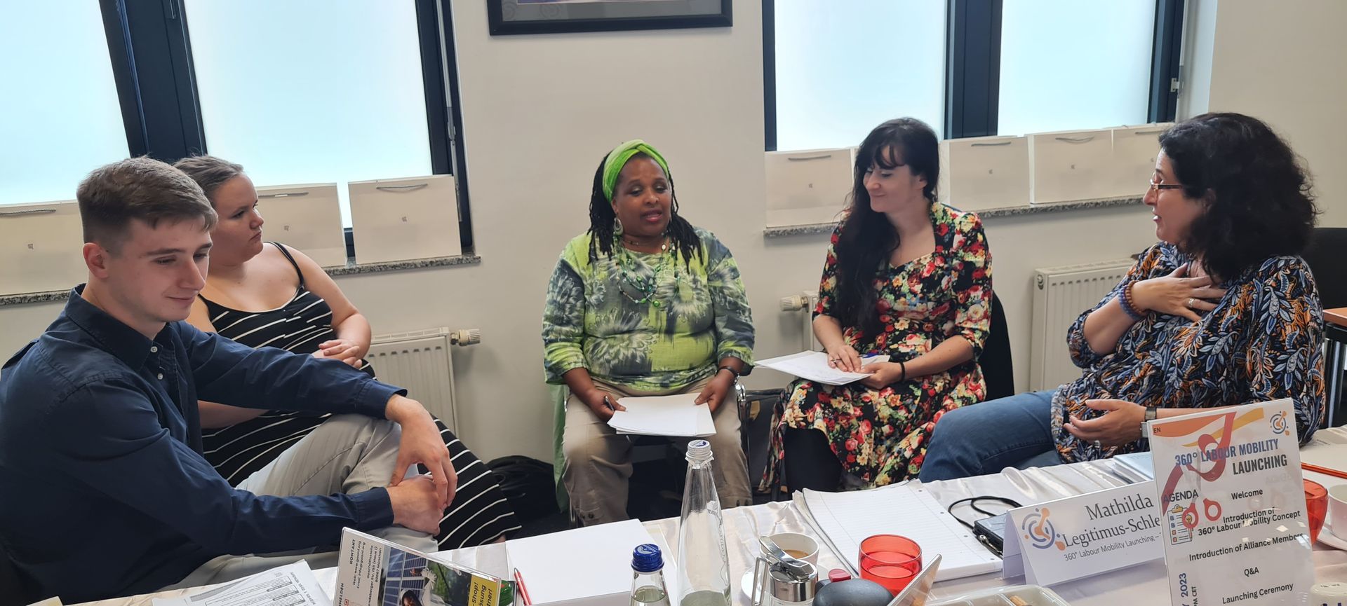A group of people are sitting around a table in a room.