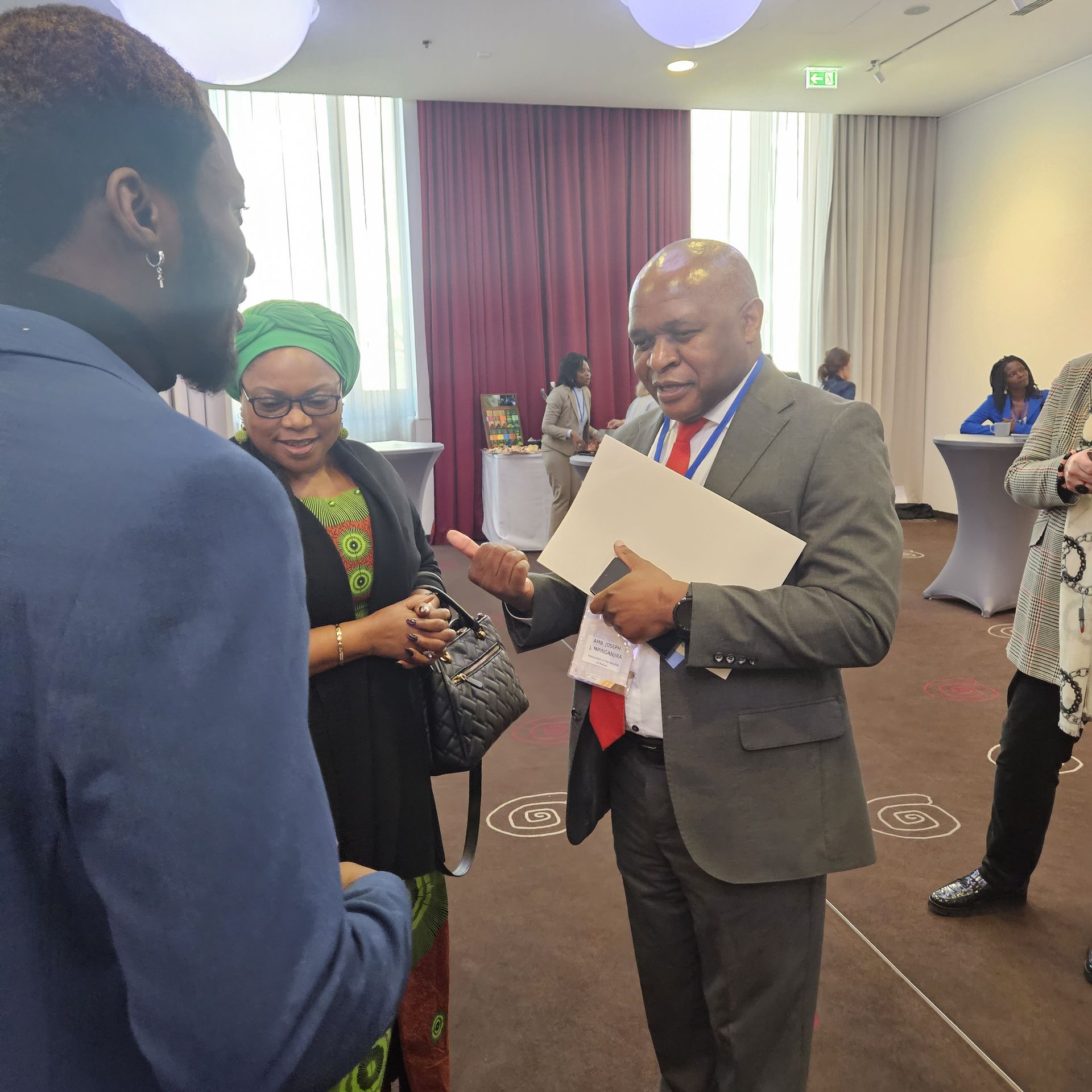 A man in a suit and tie is talking to a woman in a green turban