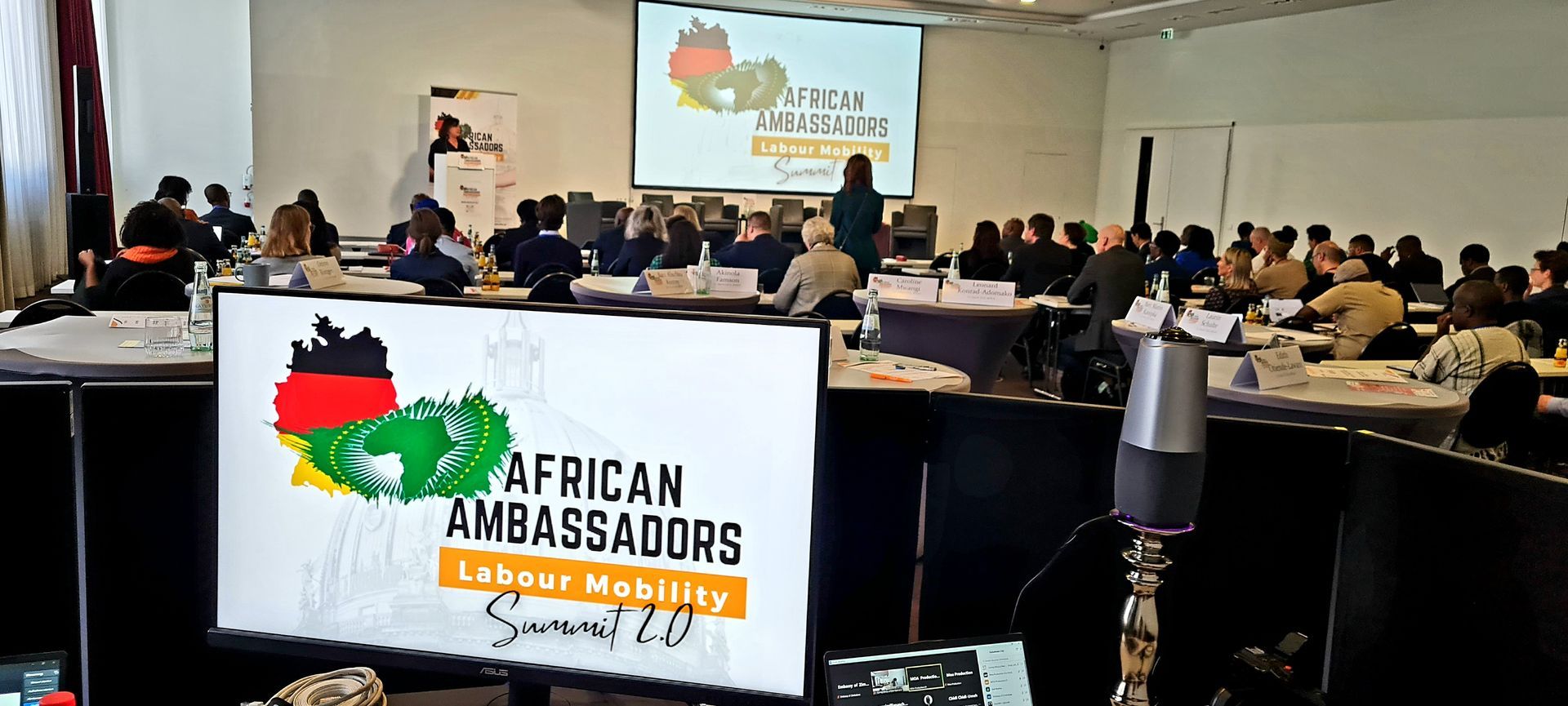 A large group of people are sitting at tables in a conference room.