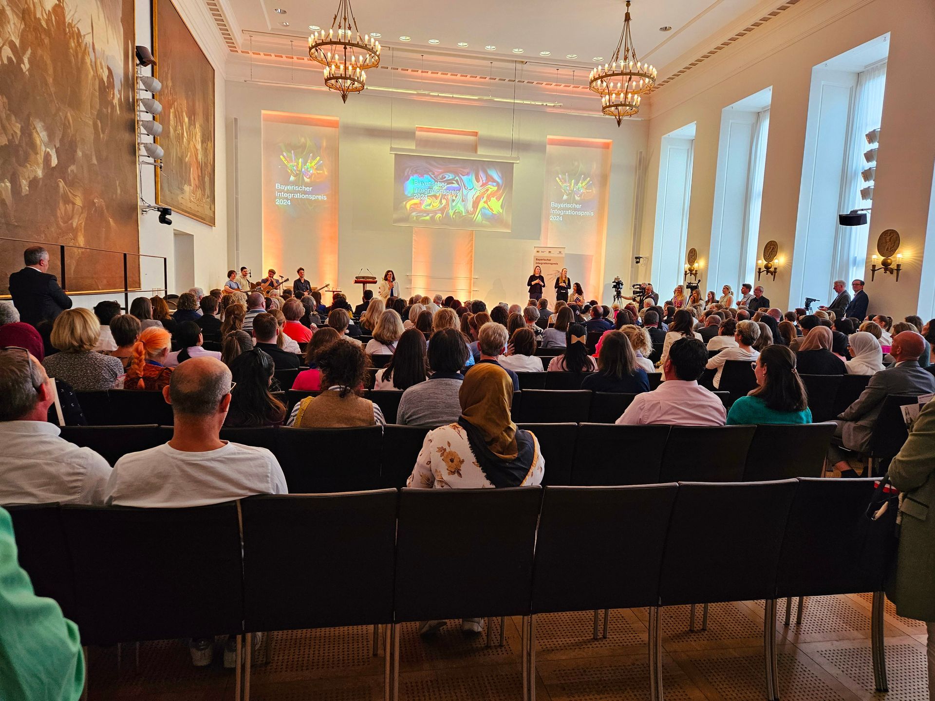 A large group of people are sitting in rows in a large auditorium.