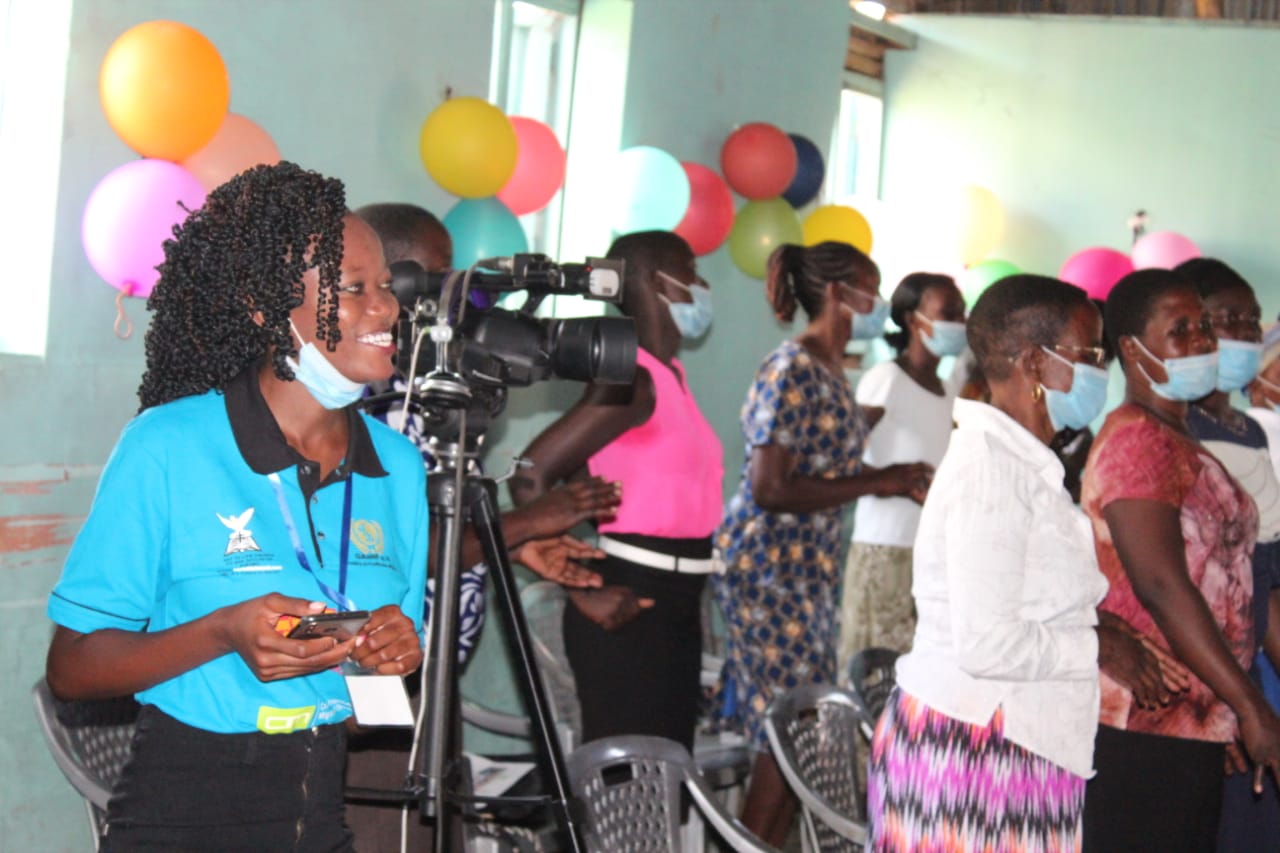 A group of people wearing face masks are standing in a room with balloons