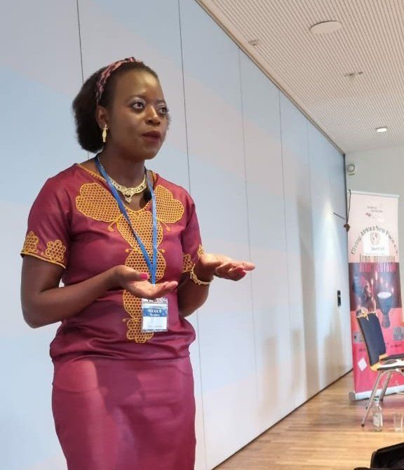 A woman in a red dress is giving a presentation