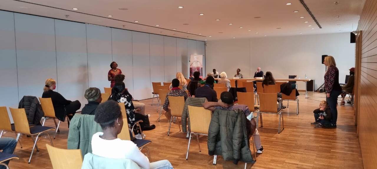 A group of people are sitting in chairs in a large room.