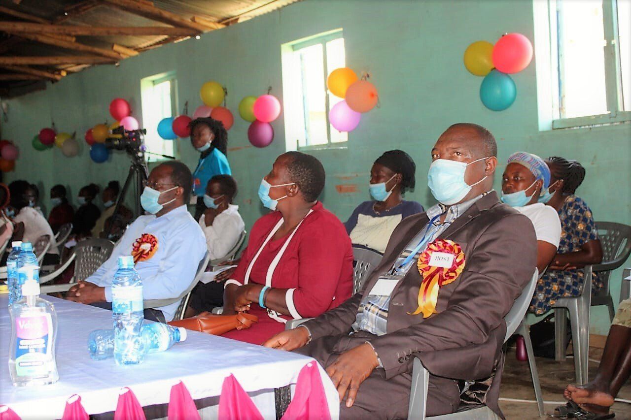 A group of people wearing face masks are sitting at a table.