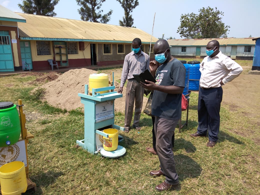 A group of men wearing masks are standing in a field in front of a building.