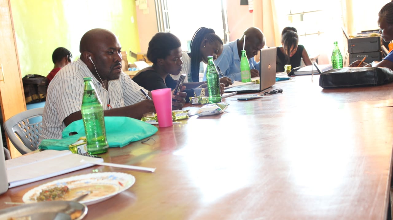 A group of people are sitting at a long table with plates of food