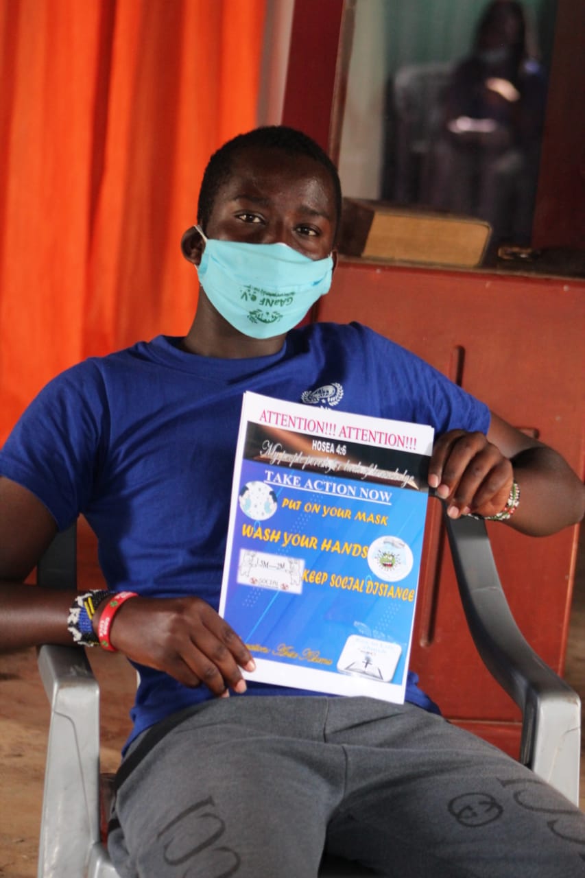 A man wearing a face mask is holding a pamphlet