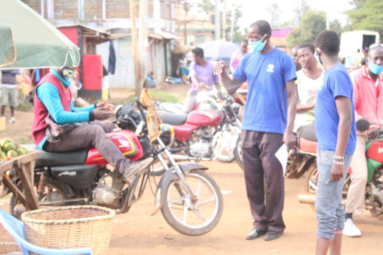A man wearing a mask is standing next to a motorcycle