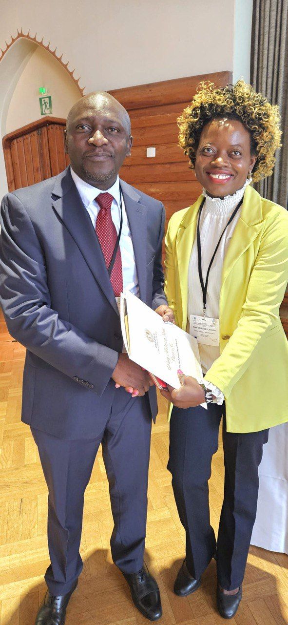 A man in a suit and tie is shaking hands with a woman in a yellow jacket.