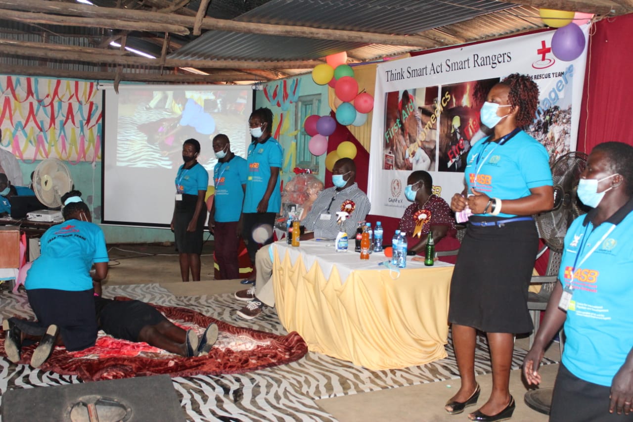 A group of people wearing face masks are standing around a table.