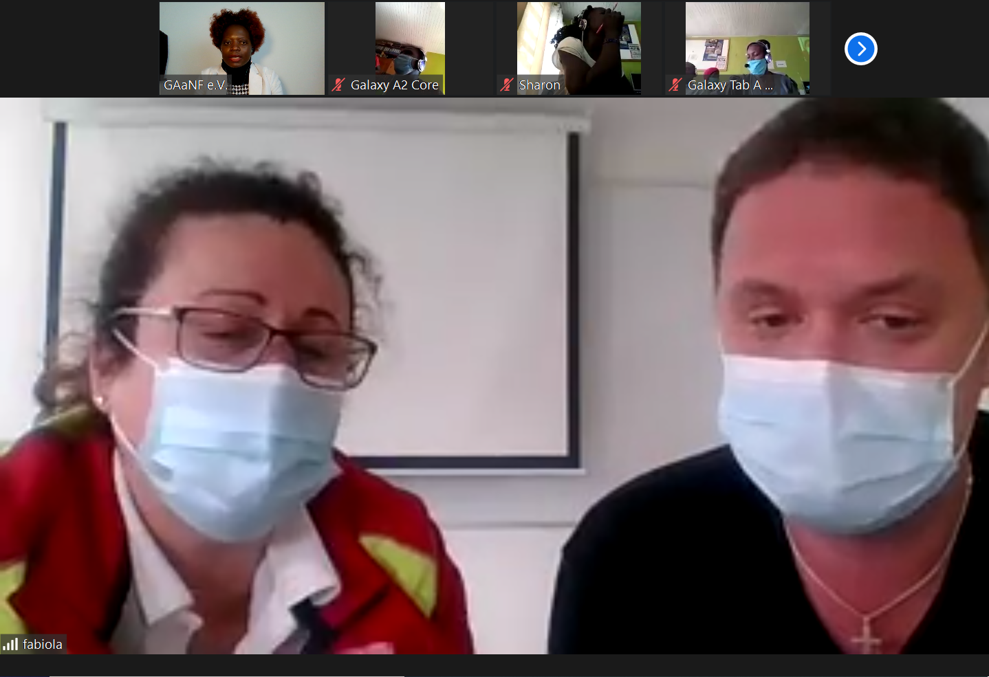 A man and a woman wearing face masks on a video call.