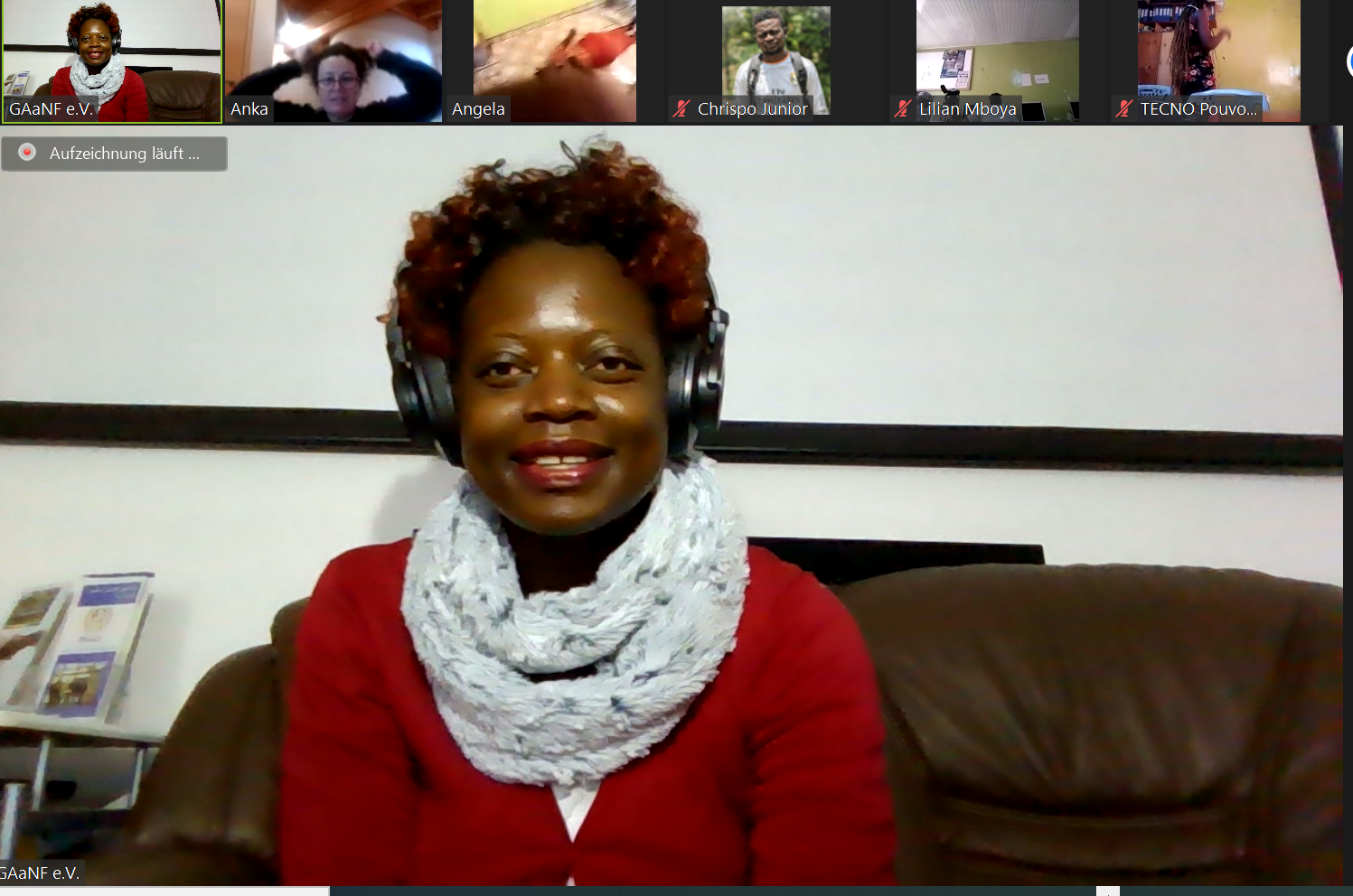 A woman wearing headphones is sitting on a couch