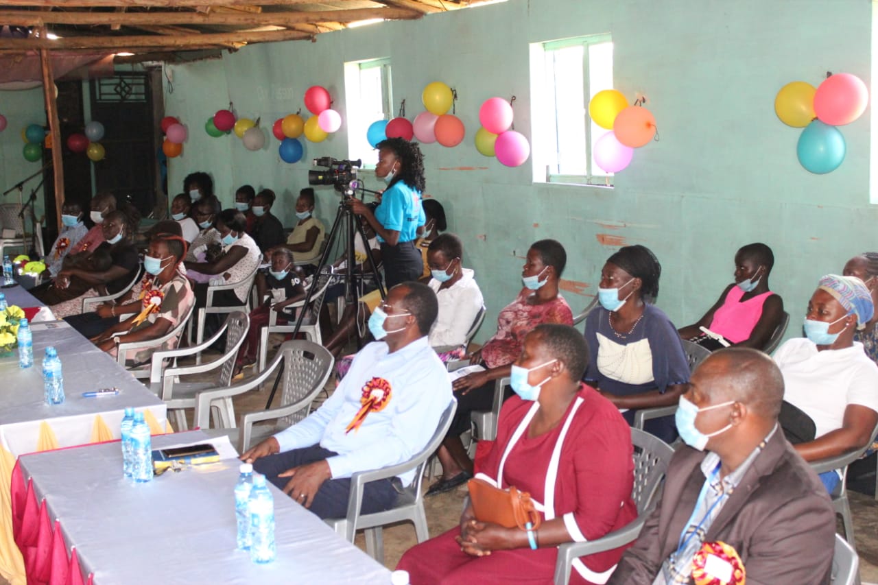 A group of people wearing face masks are sitting around a table.