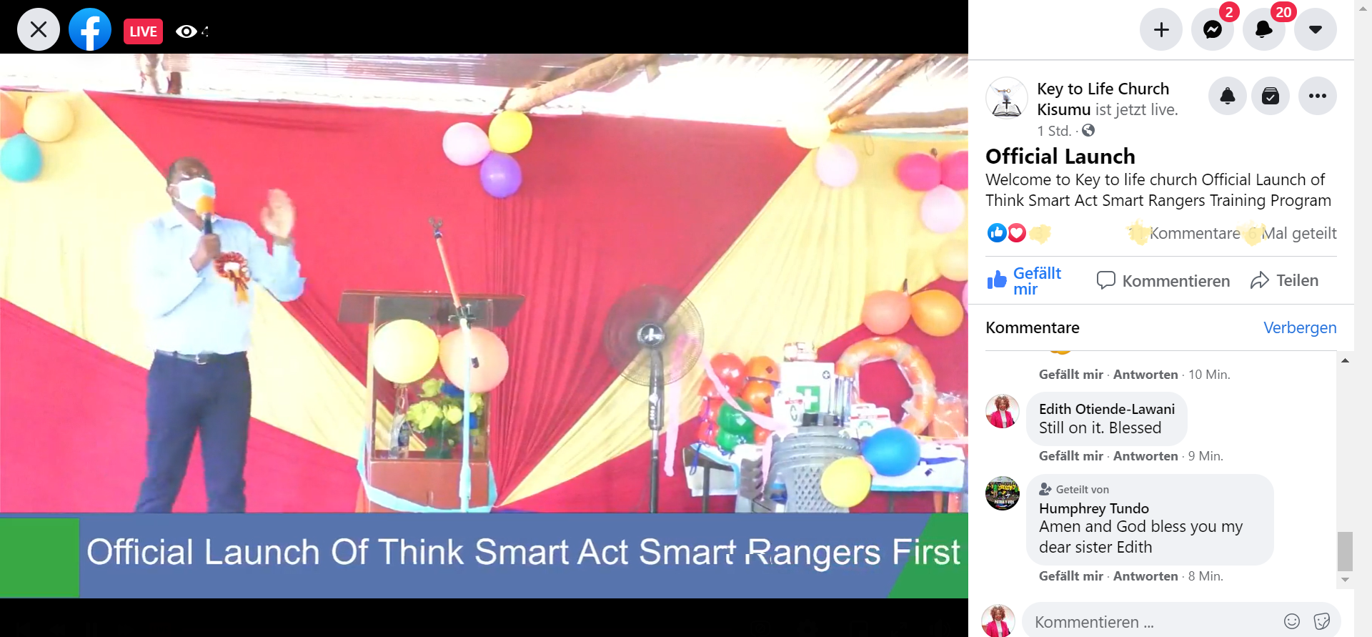 A man is standing in front of a stage with balloons and a microphone.