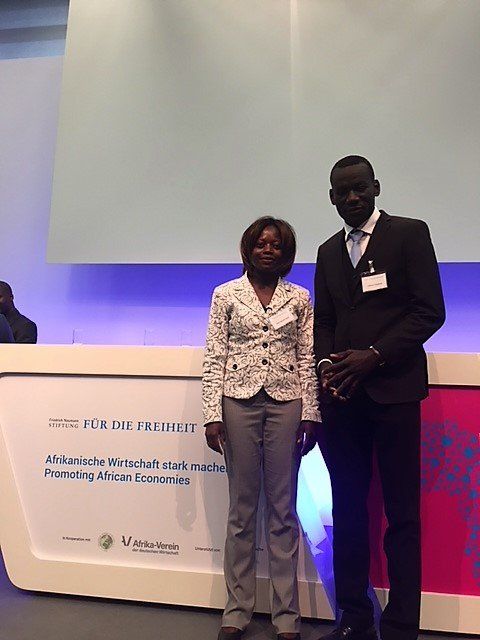 A man and a woman standing in front of a sign that says 