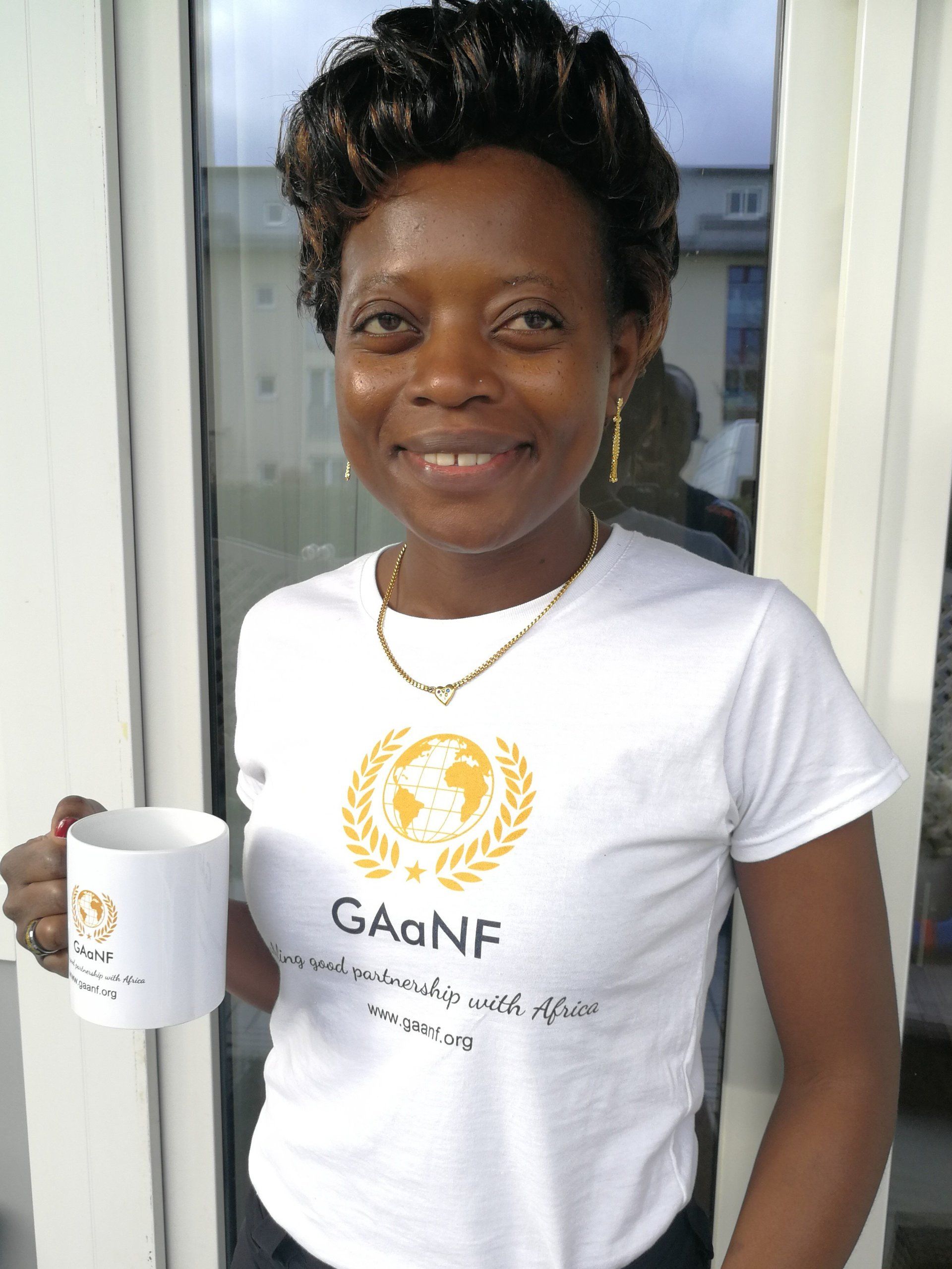 A woman wearing a shirt that says gagnf is holding a cup