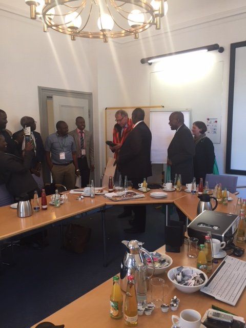 A group of people are gathered around a table in a conference room