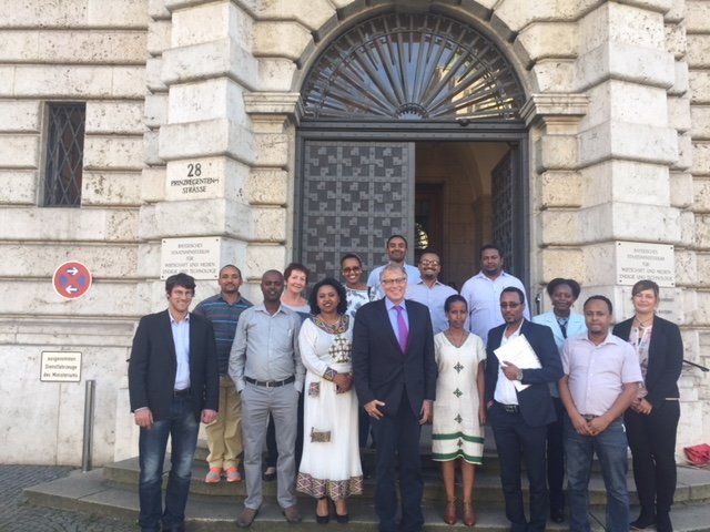 A group of people are posing for a picture in front of a building