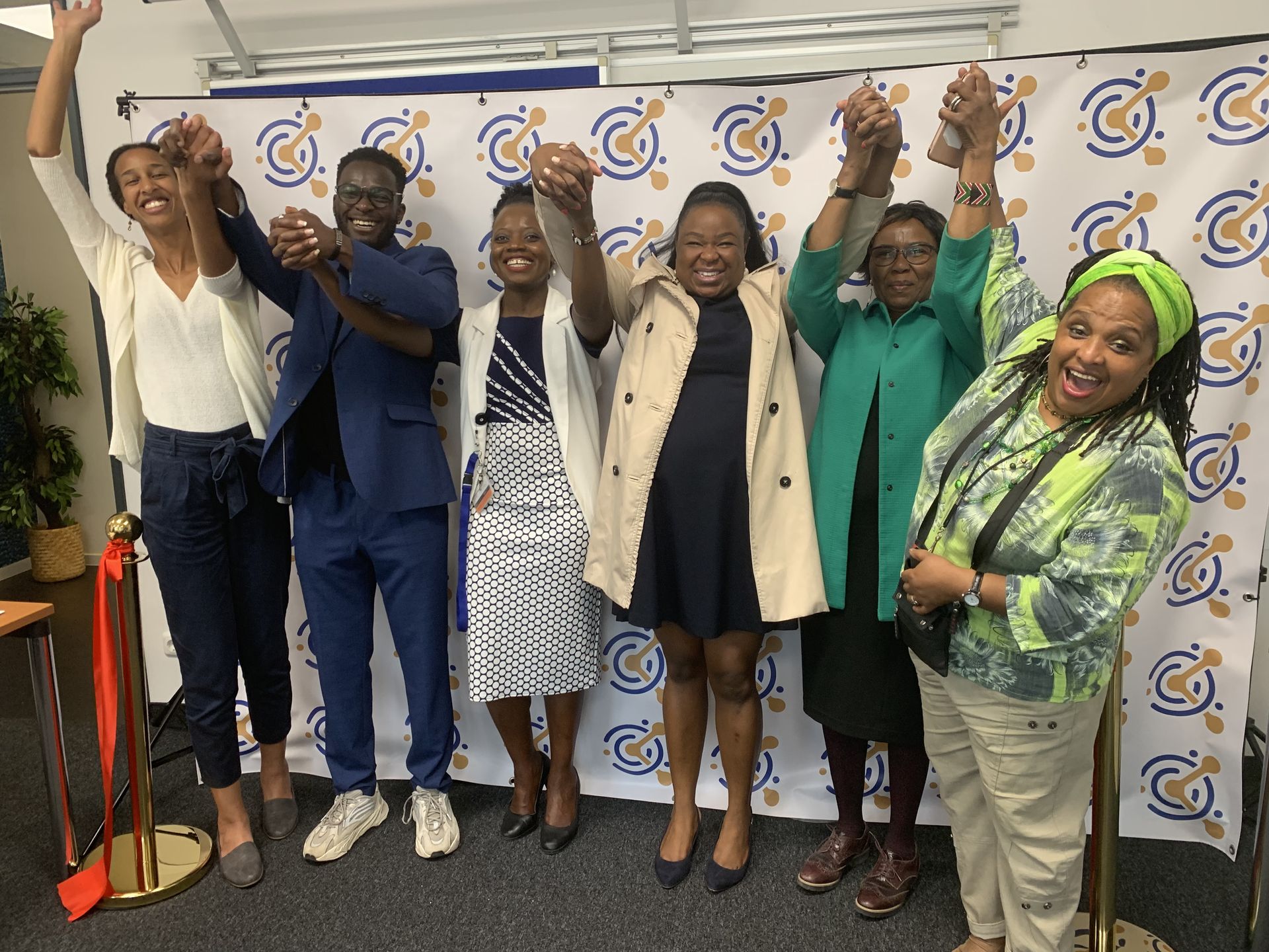 A group of people standing next to each other with their hands in the air.