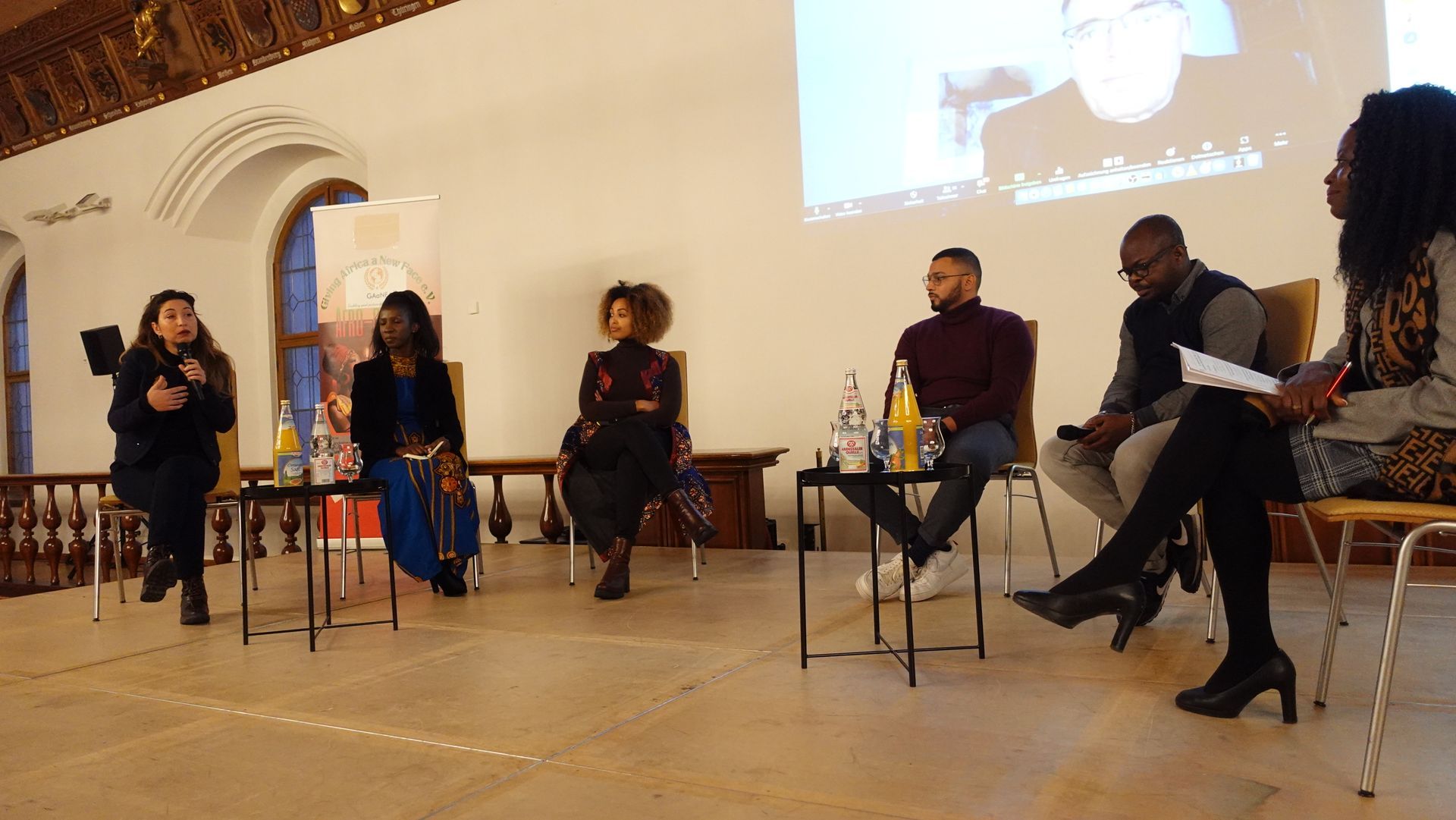 A group of people are sitting in chairs on a stage.