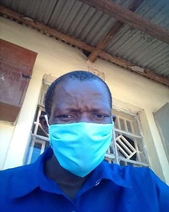 A man wearing a blue shirt and a blue face mask.