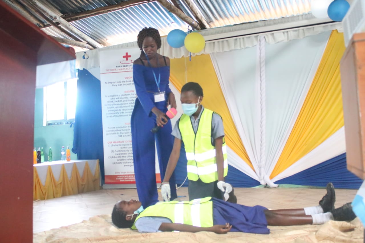 A woman is standing next to a boy laying on the floor