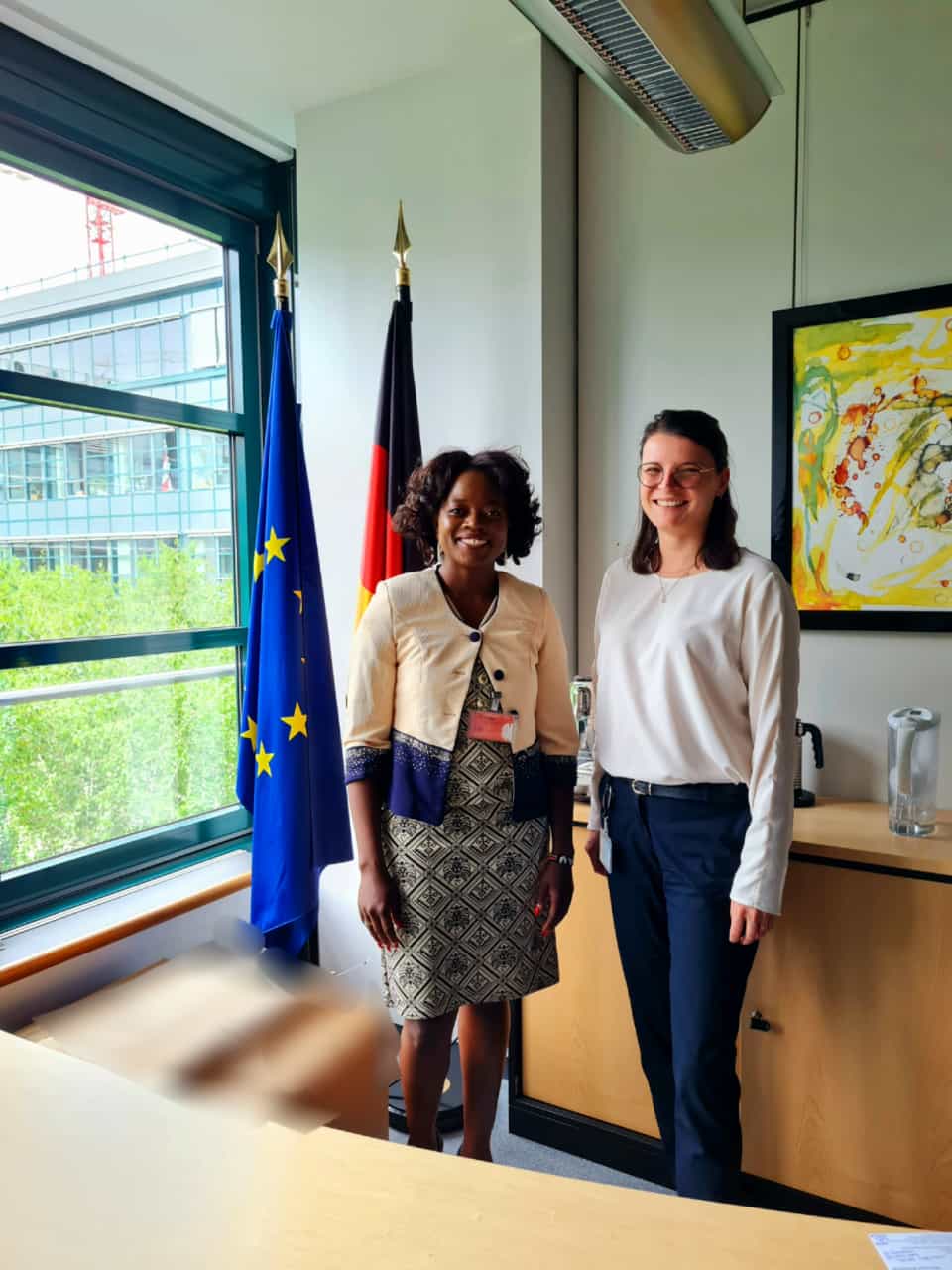 Two women standing next to each other in front of flags