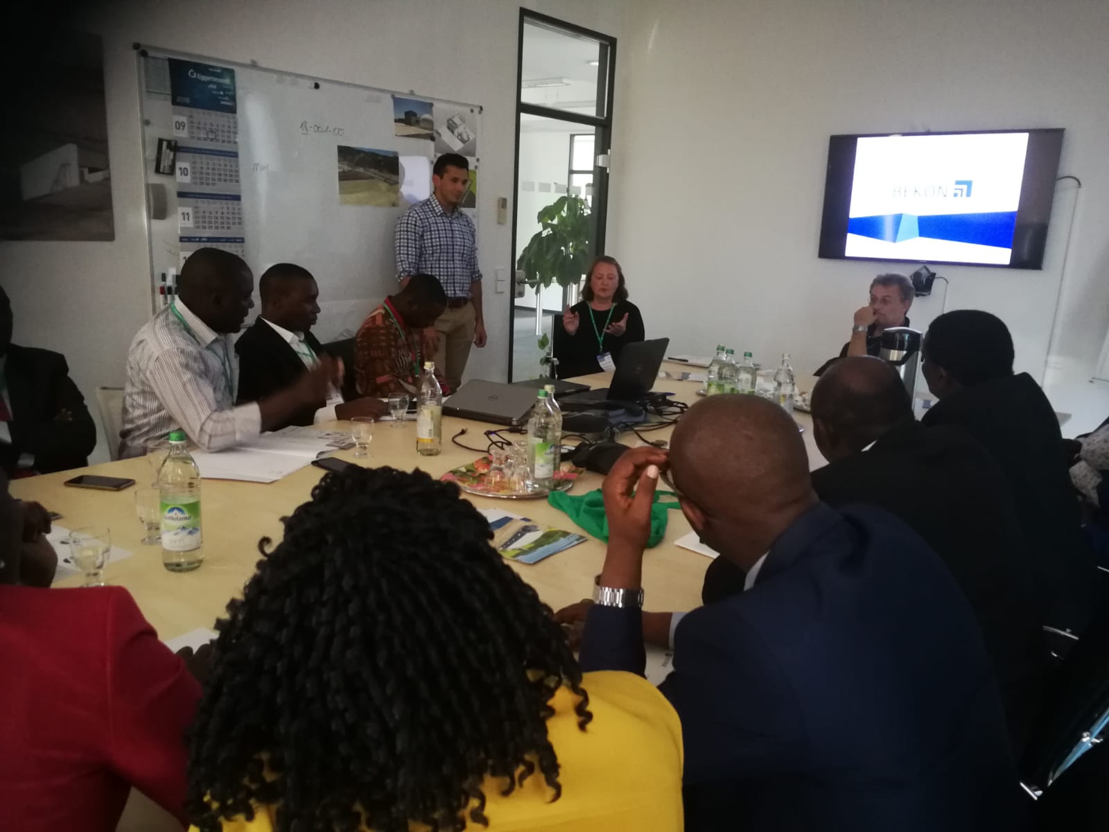 A group of people are sitting around a table in a conference room.