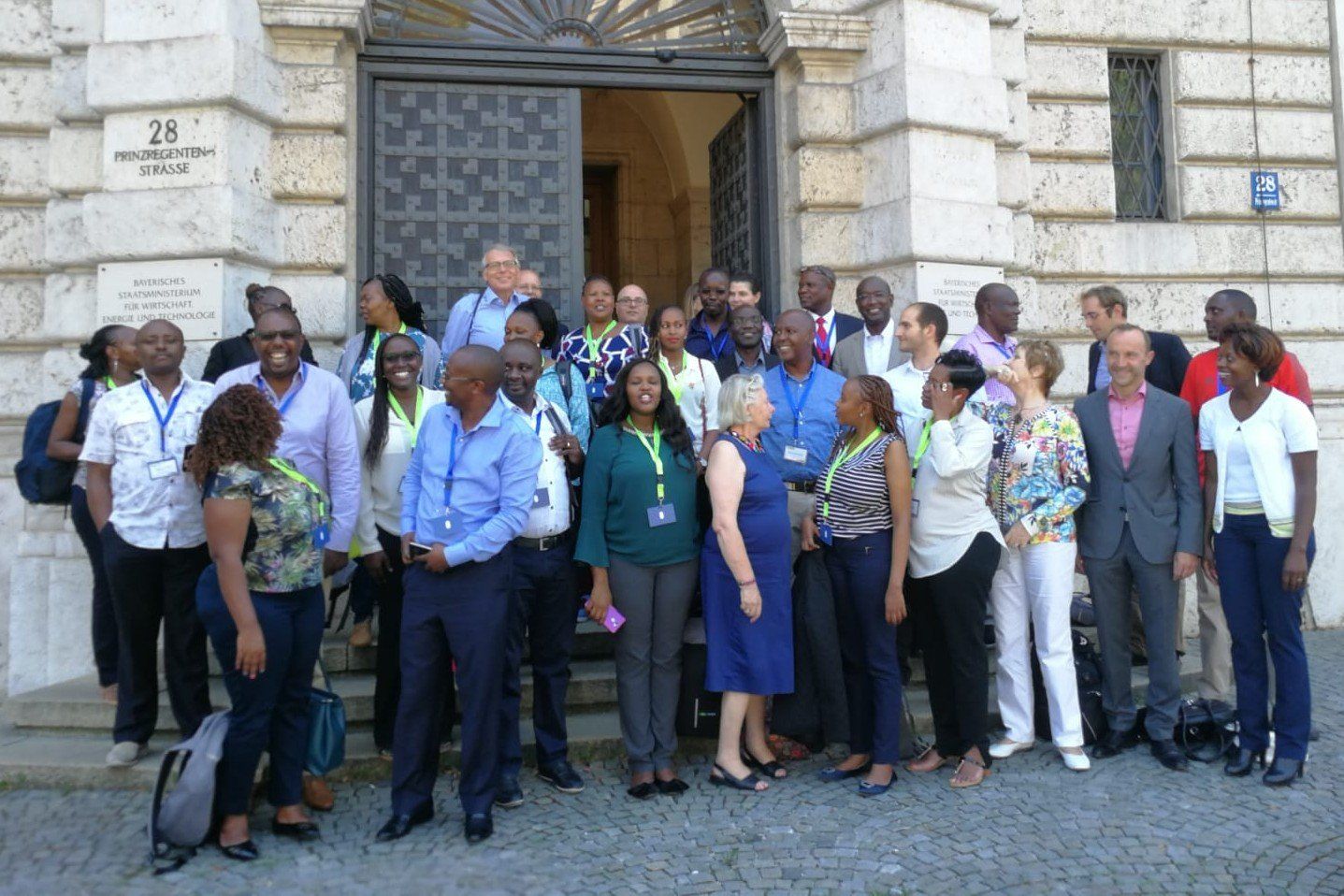 A group of people standing in front of a building with the number 25 on it