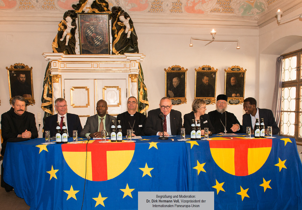 A group of people sitting at a table with flags on it