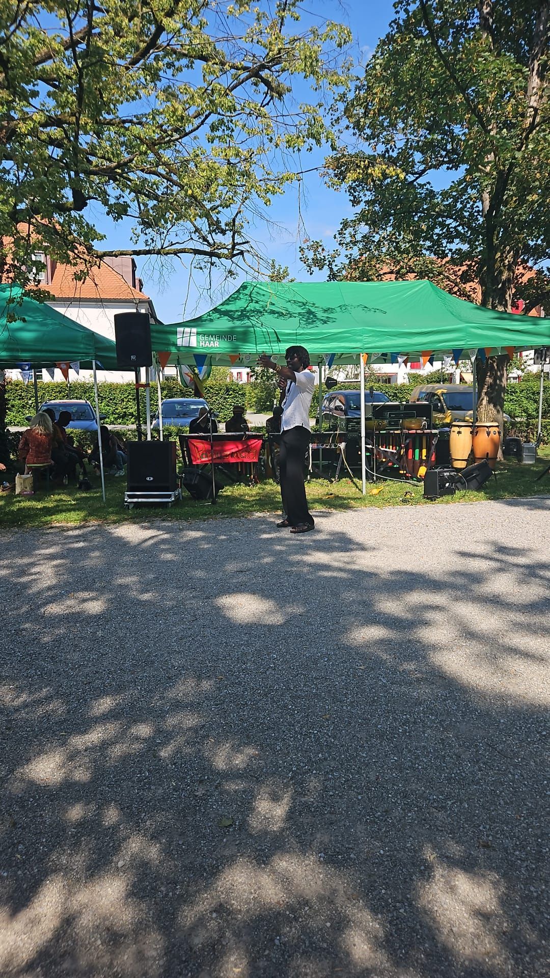 A man is standing in front of a green tent talking on a cell phone.