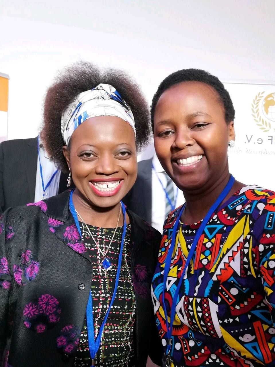 Two women are posing for a picture and one has a lanyard around her neck