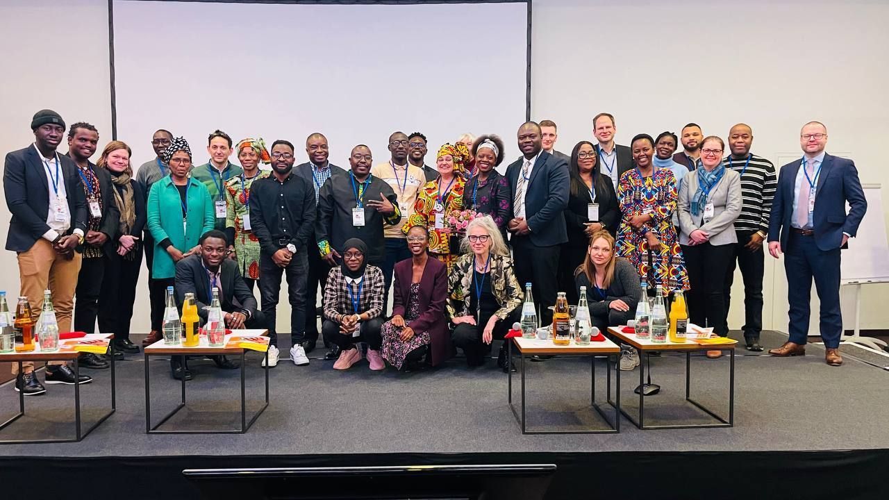 A large group of people are posing for a picture on a stage.