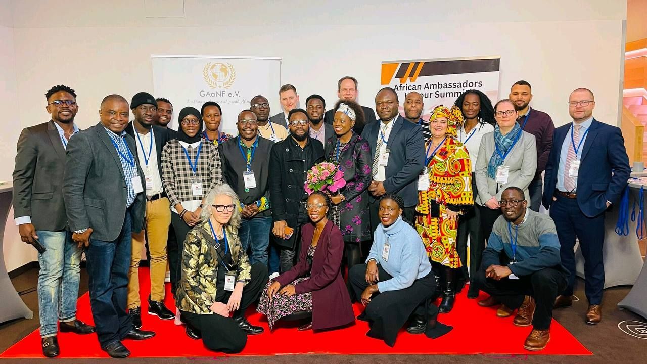 A group of people are posing for a picture on a red carpet.