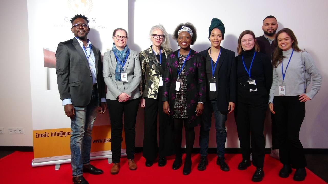 A group of people are posing for a picture on a red carpet.