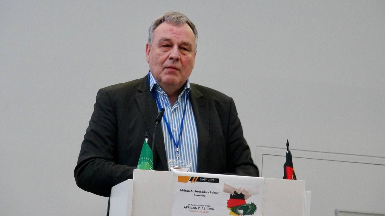 A man in a suit is standing at a podium giving a speech.