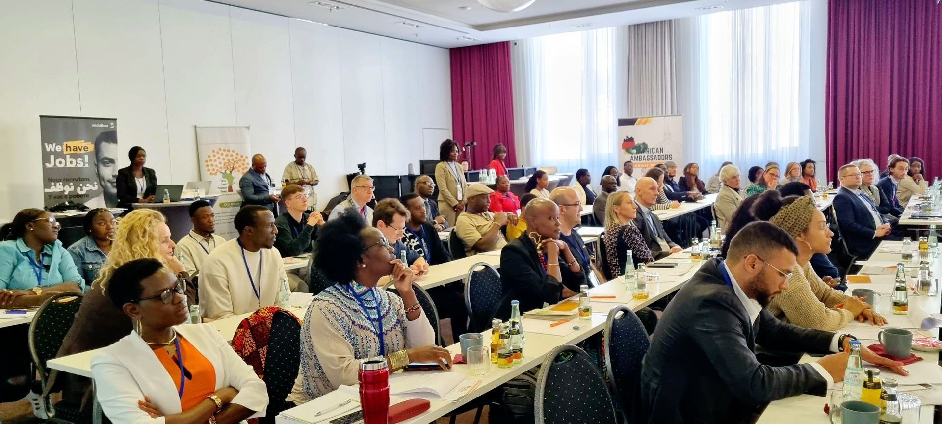 A large group of people are sitting at tables in a conference room.