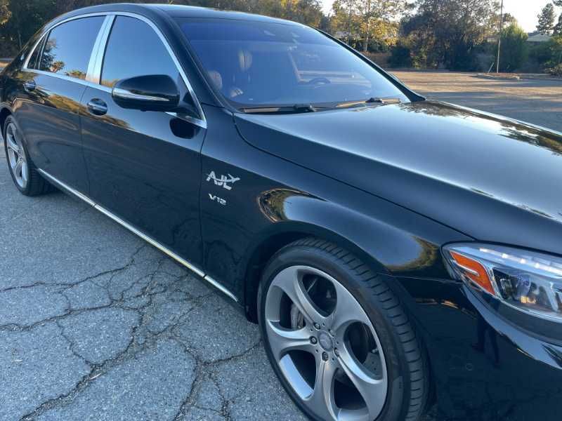 A black mercedes benz is parked on the side of the road