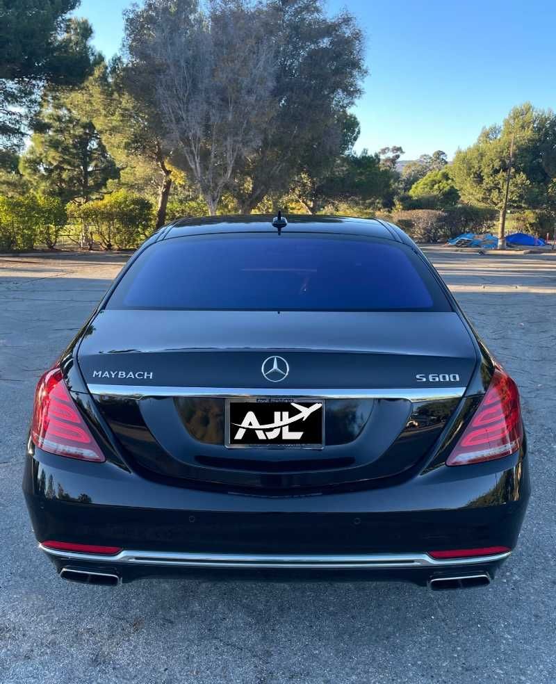 A black mercedes maybach is parked in a parking lot