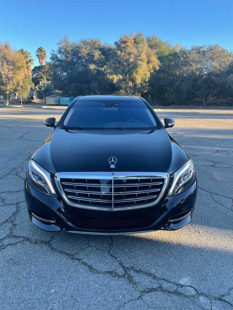 A black mercedes benz s class is parked in a parking lot.