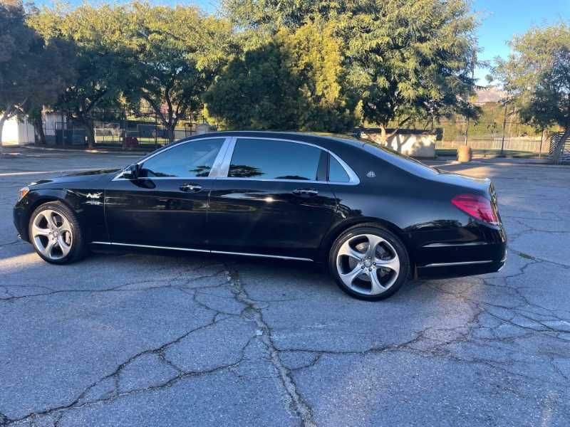 A black mercedes benz s class is parked in a parking lot.