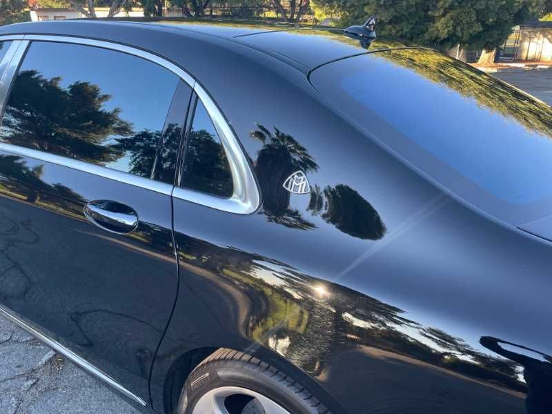 A black car is parked on the side of the road.