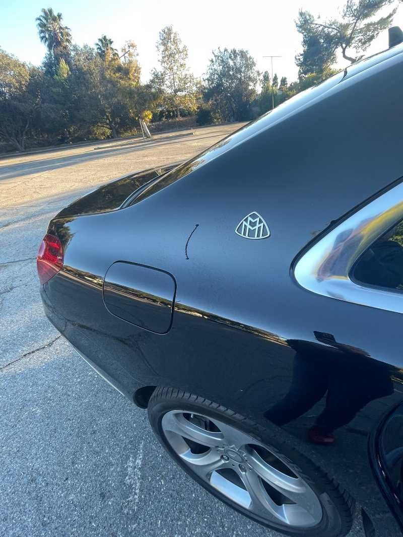 A black car is parked on the side of the road.