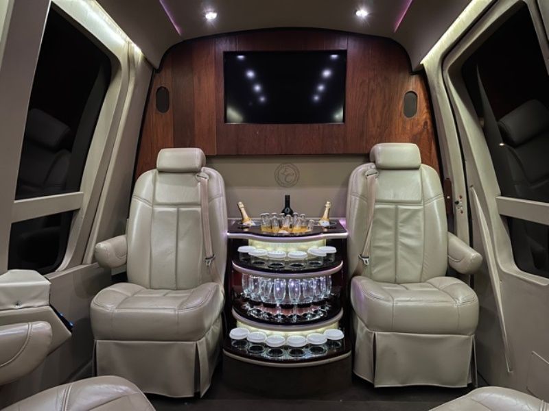 The inside of a helicopter with two seats and a table with wine glasses on it