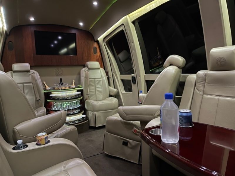 A bottle of water sits on a table in the back seat of a van.