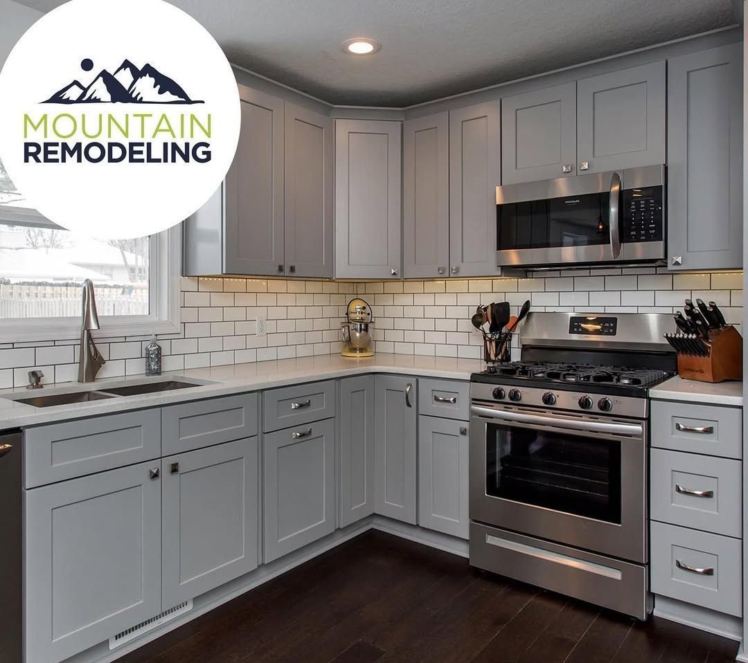 A kitchen with gray cabinets and stainless steel appliances.