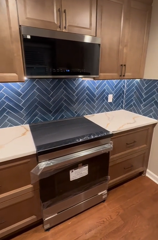 A kitchen with stainless steel appliances and wooden cabinets.