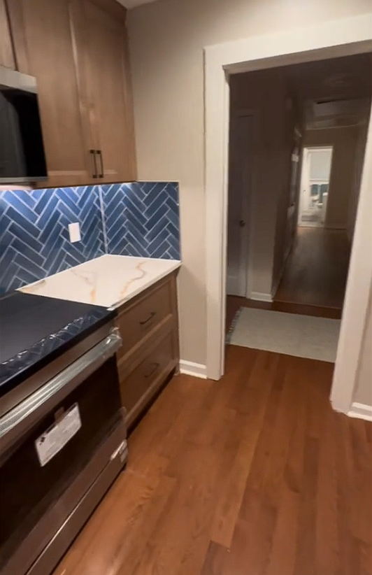 A kitchen with hardwood floors and stainless steel appliances