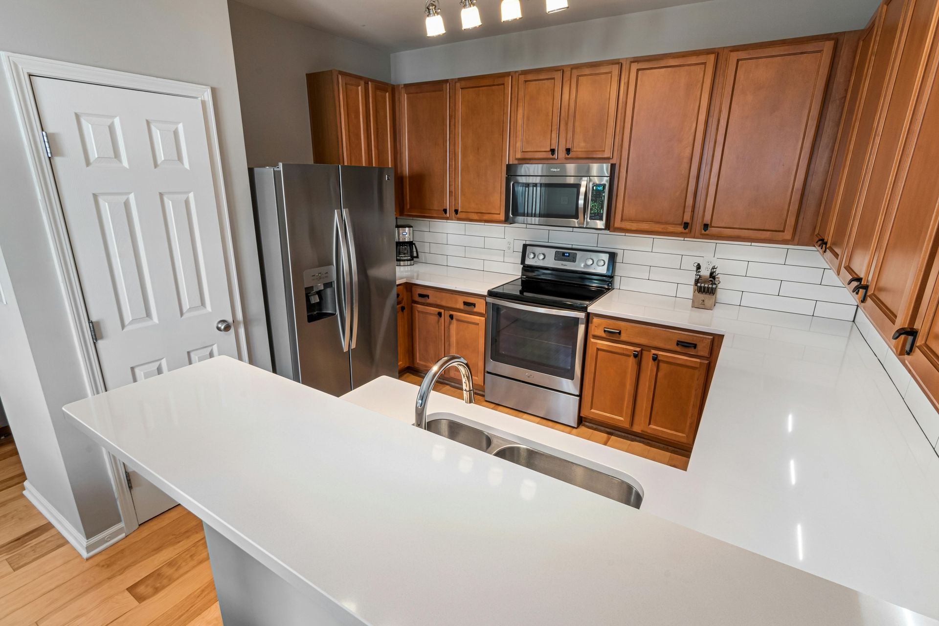 A kitchen with stainless steel appliances and wooden cabinets.